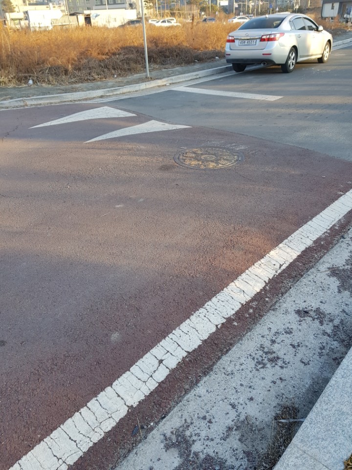 통행방향에 주차된차량으로 인해 멘홀두껑쪽으로 통행되어야하는 도로상황