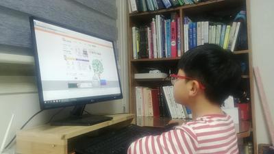 학생이 pc 모니터를 통해 온라인 학습방 사이트를 살펴보고 있다